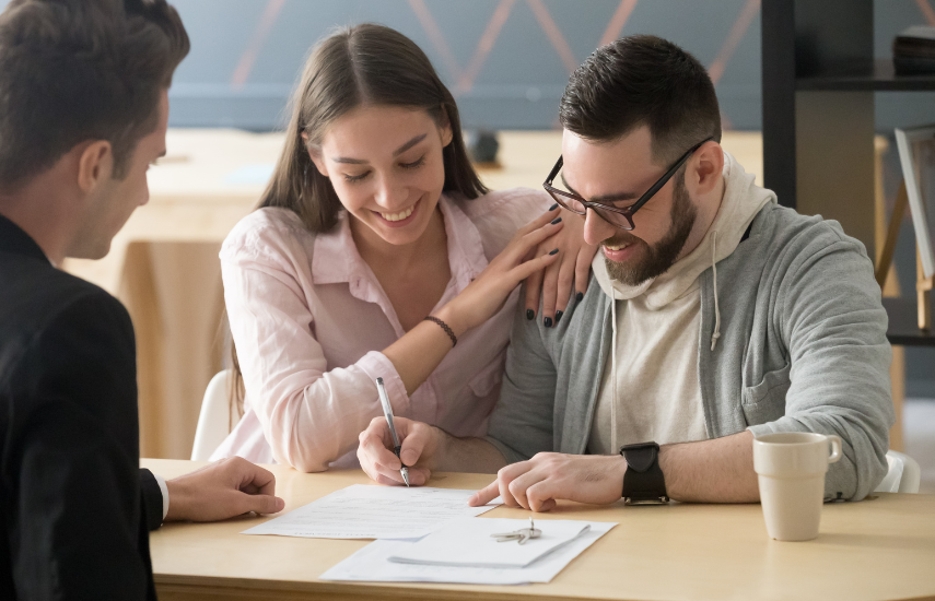 Couple Smiling and signing papers